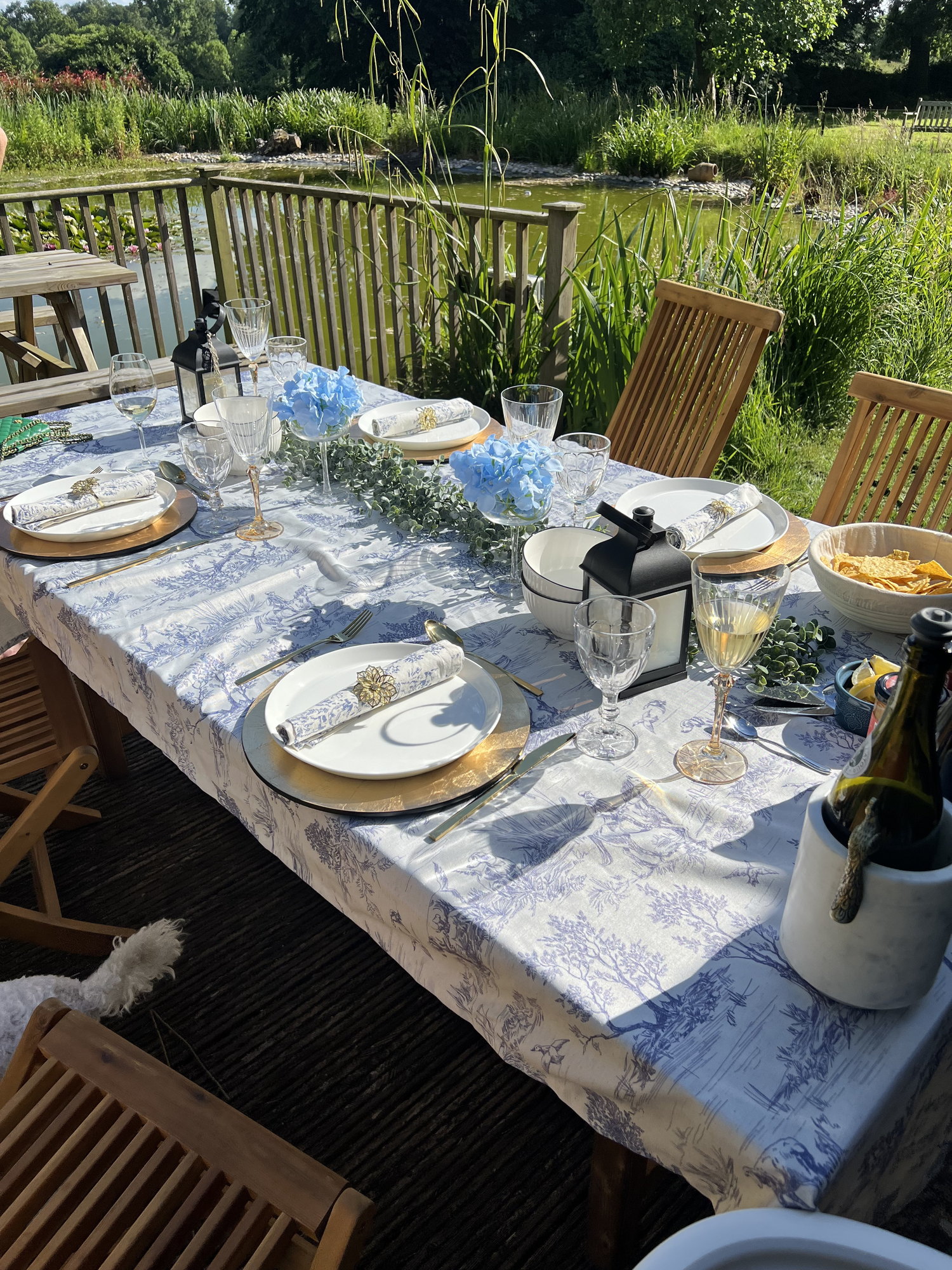 A table laid in blue and white by the pond