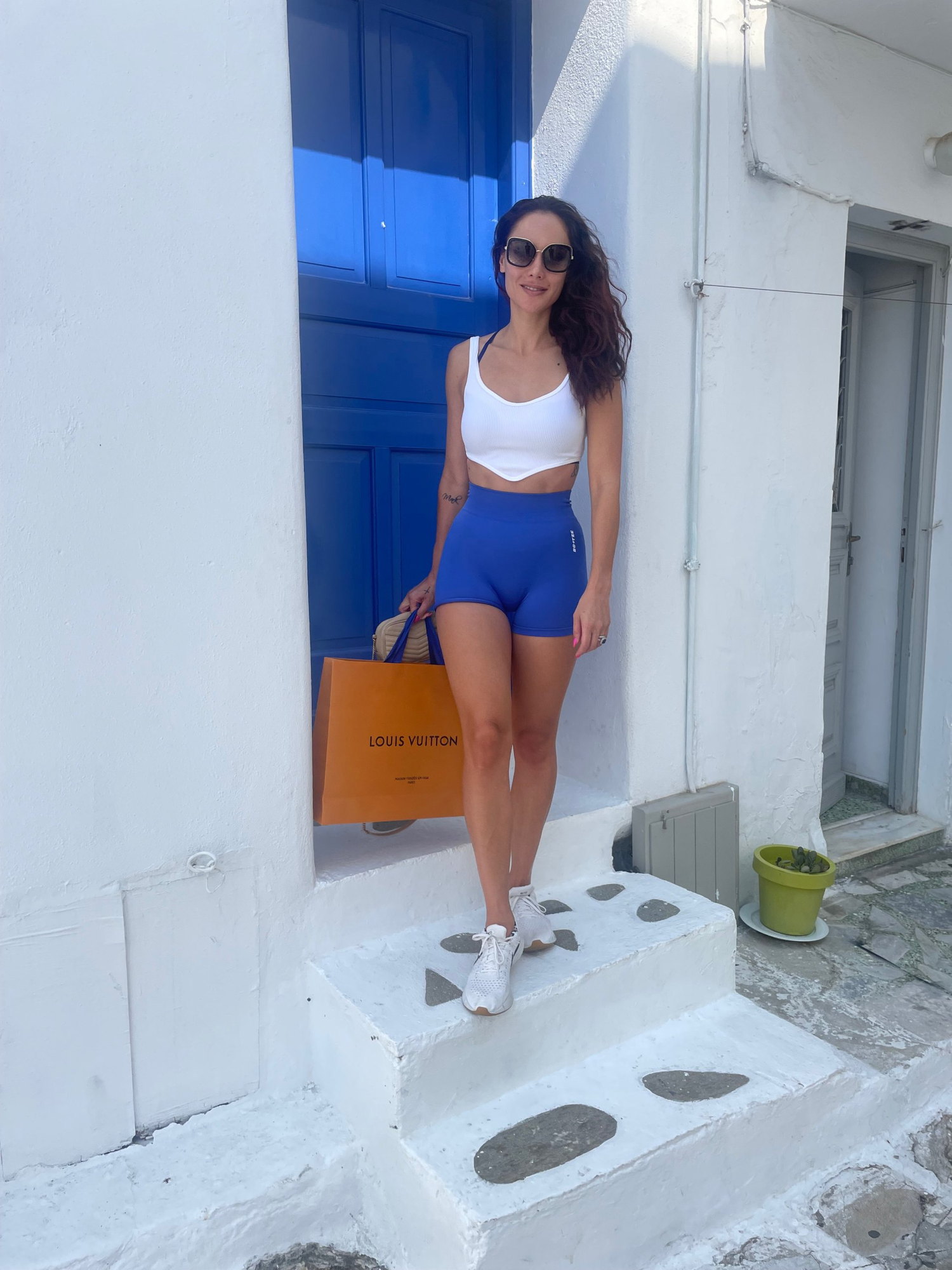 Chelsea Green in a Mykonos backstreet with a Louis Vuitton bag